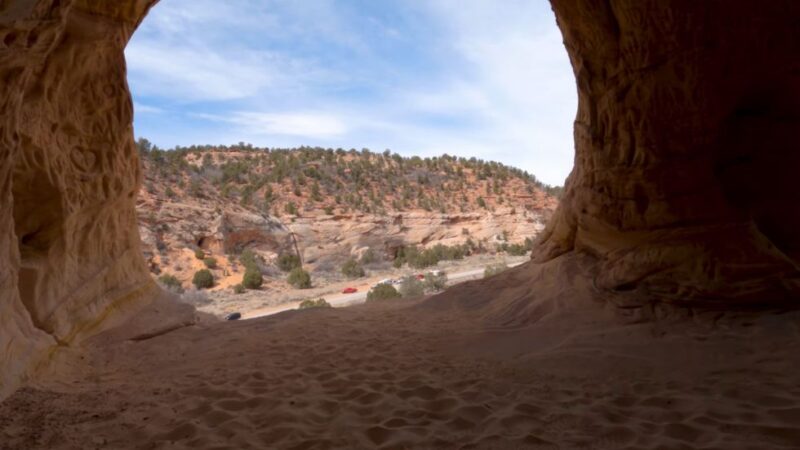 View from inside Moqui Caverns looking out over sandstone cliffs and desert valley