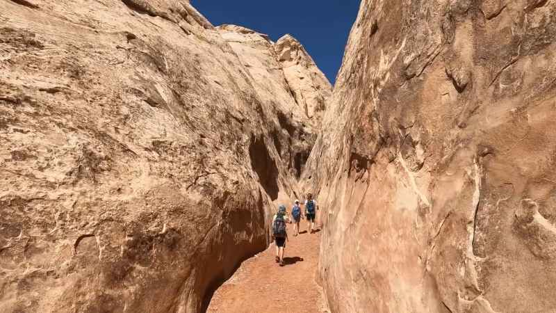 Adventurers hiking through tight passages in Ding and Dang Slot Canyons