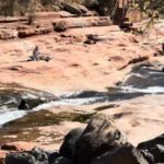 People relaxing by the water and rocks at Sedona’s swimming holes