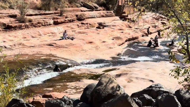 People relaxing by the water and rocks at Sedona’s swimming holes