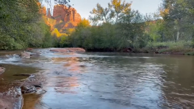 View of the creek at Crescent Moon Picnic Site with red rock cliffs in the background