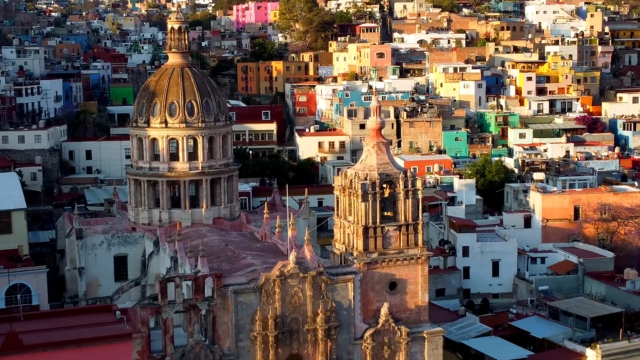 A view of Guanajuato shows colorful houses surrounding historic churches