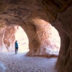 Person walking inside Moqui Caverns sandstone tunnel