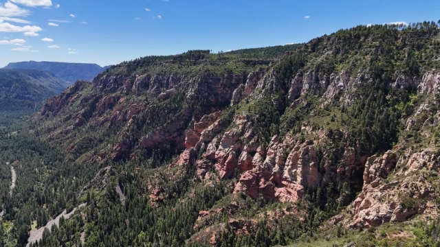 A wide view of Sedona’s red rock cliffs and green forested slopes
