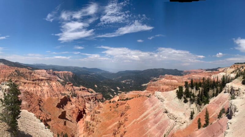 Wide view of colorful cliffs and forested ridges along Cedar Breaks Scenic Byway under a clear sky